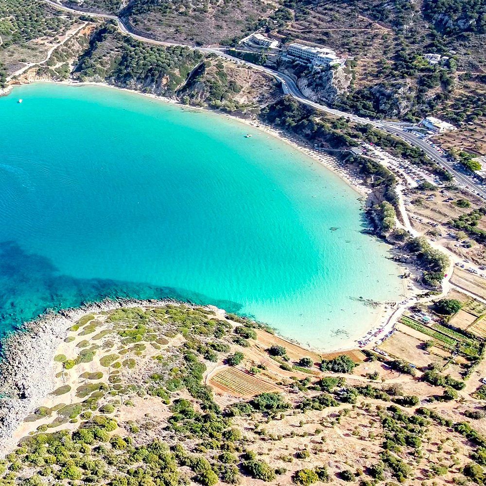 Secluded sunlit cove with clear water and rocky cliffs — the kind of hidden escape you can discover when you become a travel agent