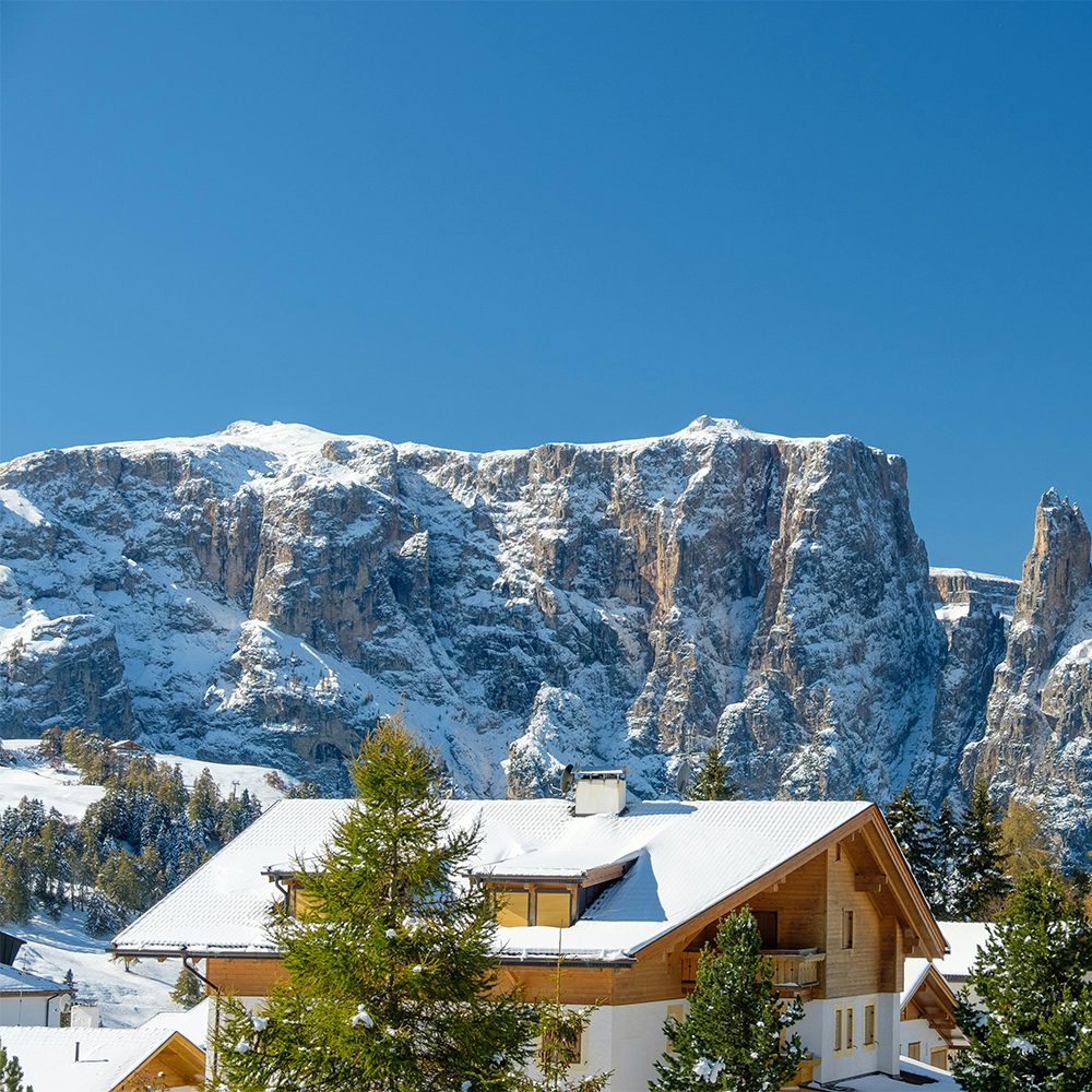 Cosy ski chalet in a snowy mountain setting — the kind of winter escape you can book when you become a travel agent