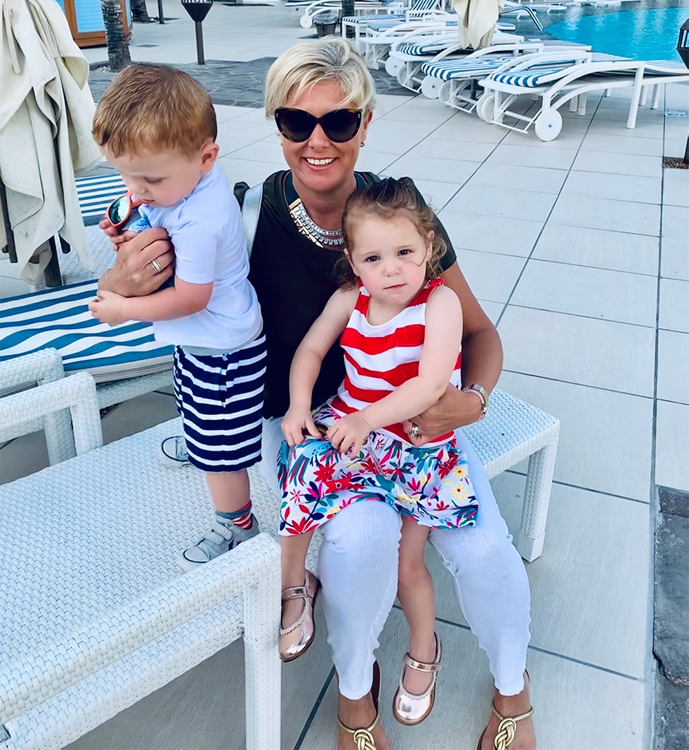 Parent sitting by the pool with children — enjoying the lifestyle made possible by starting a travel business from home